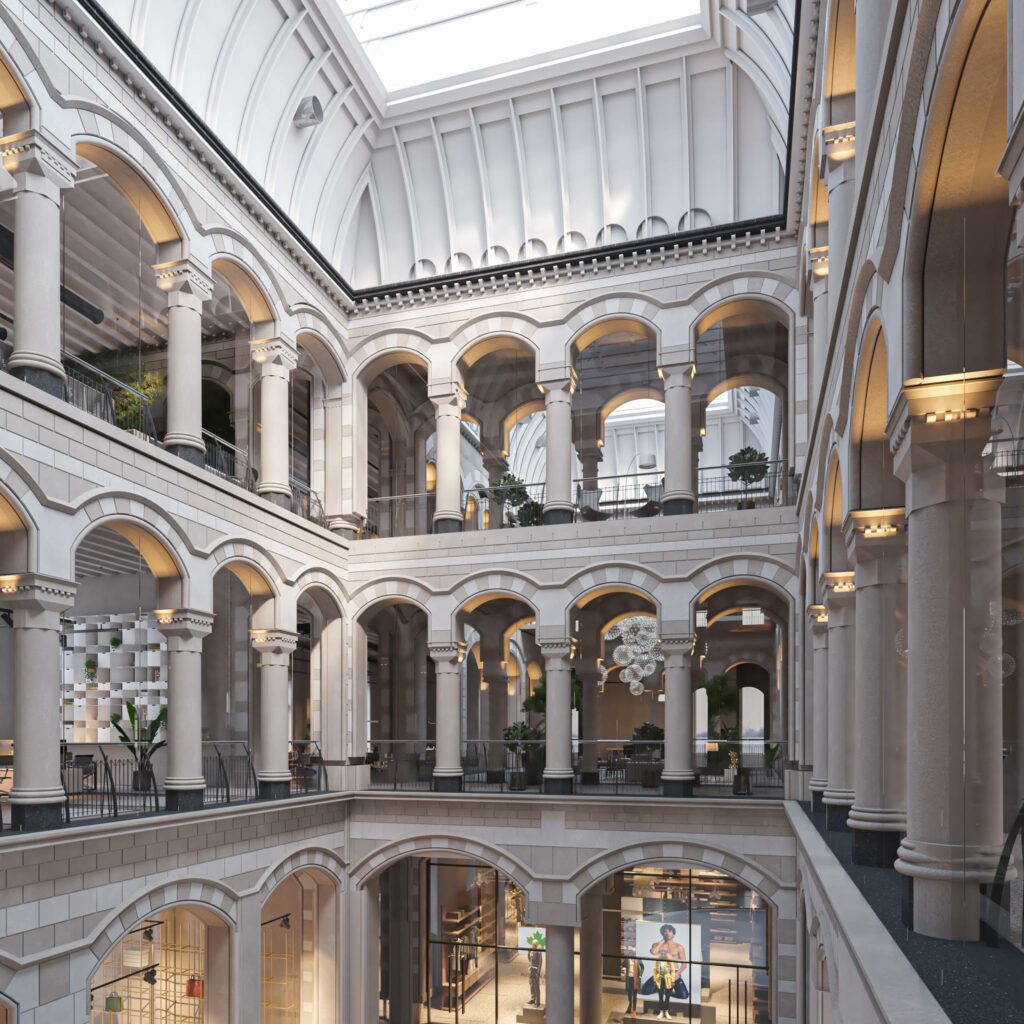 Een lichtovergoten, monumentale binnenruimte met meerdere verdiepingen en klassieke bogen aan de Nieuwezijds Voorburgwal.